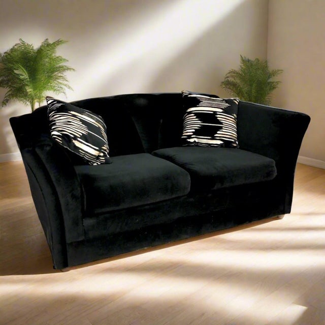 1970s Black channel back loveseat has velveteen upholstery and rich black color. Curved arms, 2 throw pillows original to...