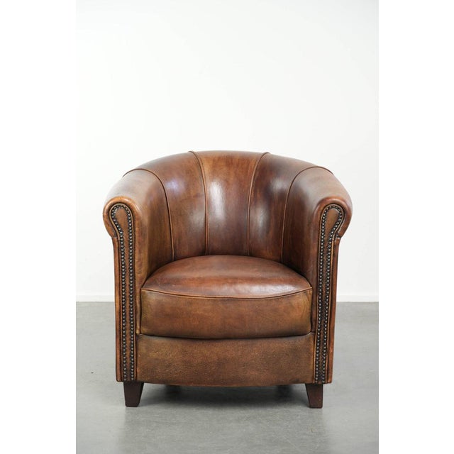 This characterful sheepskin club chair has developed a beautiful patina over the years and is finished with decorative...