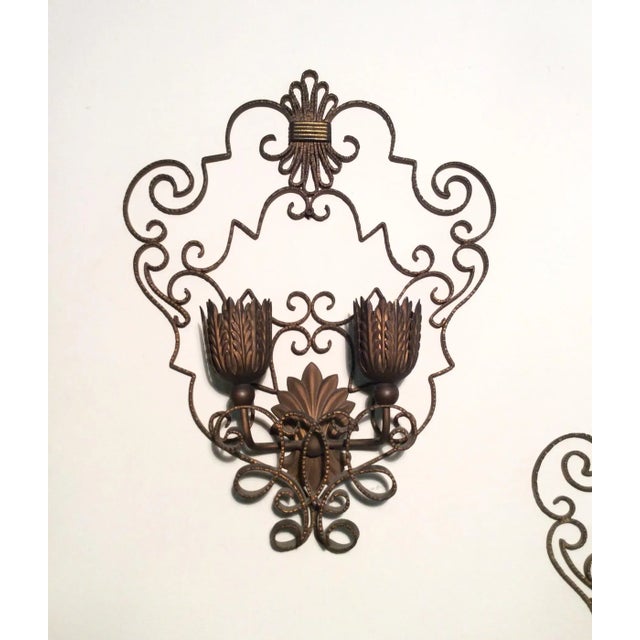 Pair of 1940 wall sconces in burnished gilded iron. European Plug (up to 250V).The wiring of this item may be original and...