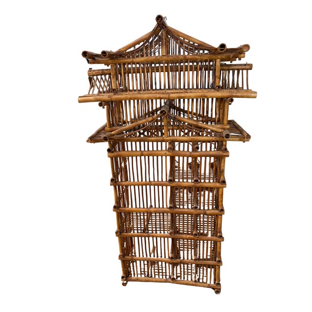 A striking vintage pagoda-style bamboo etagere showcasing sculptural architectural lines inspired by traditional Asian...