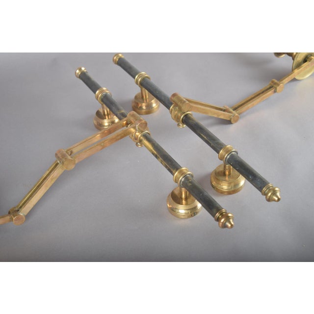 A striking and highly collectible pair of Maison Jansen wall lamps, crafted entirely in brass and designed with elegant...