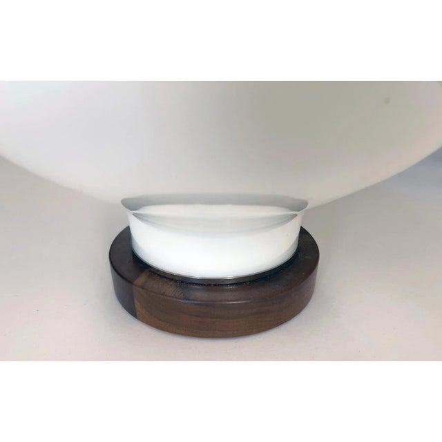 1960s lamps each bulbous lamp of white cased glass fitted with a walnut neck and base.