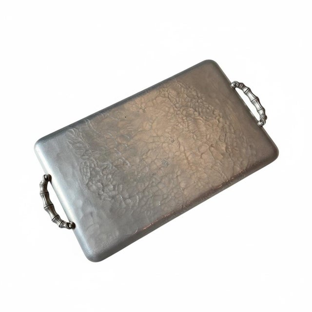 Elevate your bar cart or tabletop with this beautiful hand-hammered aluminum serving tray featuring an embossed bamboo and...