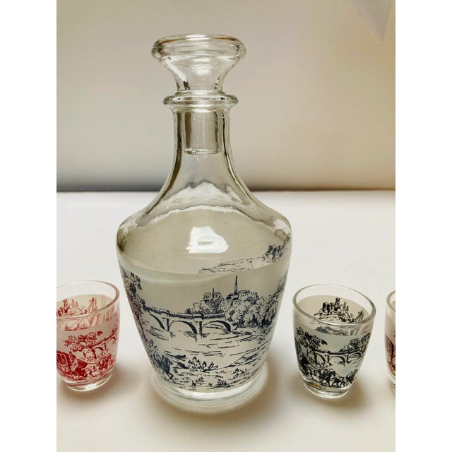 Very cute old world graphics decanter set. 1 decanter and 6 shot glasses.