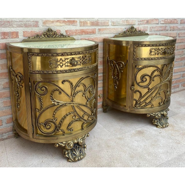 Striking pair of Louis XVI demilune cabinets crafted in bronze, dating to the mid-20th century. Each cabinet features a...