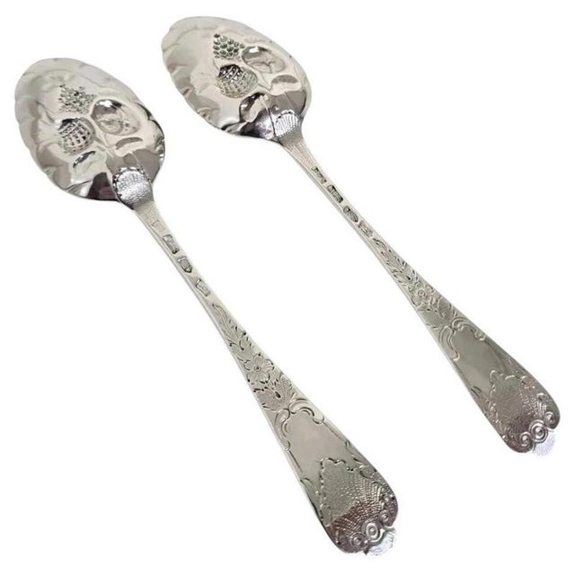 A fine pair of Georgian sterling silver serving spoons, dating from 1737 and 1763. The generously proportioned bowls are...