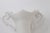 Elegant white porcelain urn vase featuring a beautifully sculpted silhouette with ornate scroll handles, a scalloped rim,...