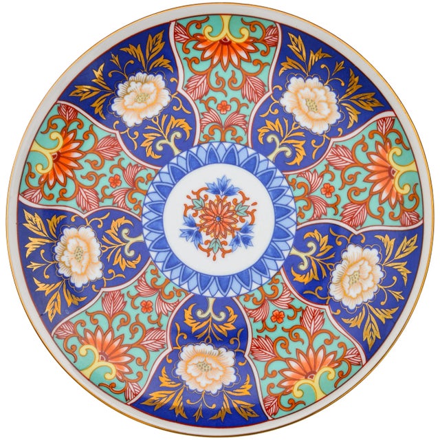 Vintage gold Imari porcelain plate hand-painted with intricate floral pattern and ornate details in vibrant color...