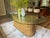 Vintage dining table has a pedestal base constructed from pencil reed rattan. The base features a decorative braided rope...