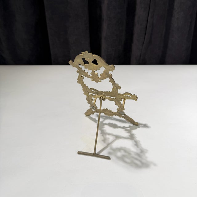 A beautiful solid brass easel stand. Crafted from cast brass, this decorative display piece features intricate Baroque-...