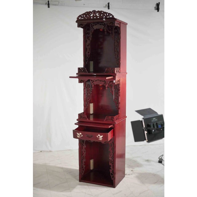 Vintage Chinese carved elmwood display curio. In red lacquer with inlays in its only drawer, with ornate dragon carving to...