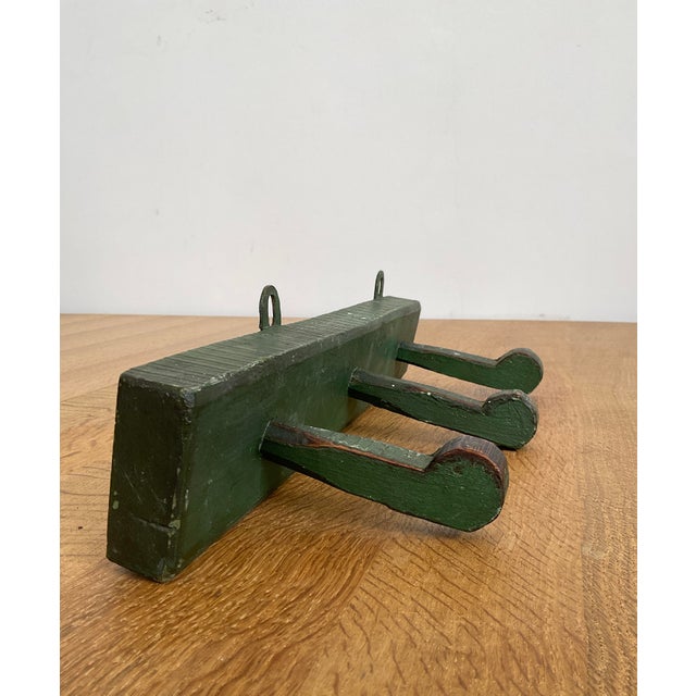 Bring authentic vintage charm and practical style to your home with this Antique Rustic Wooden Peg Hook Strip in Green....