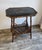The table features a distinctive octagonal top finished in a rich, black Japanned lacquer. The surface is hand-painted...