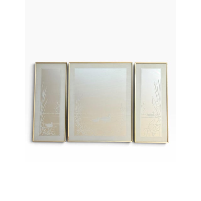 An elegant vintage three-piece mirror set featuring graceful swan motifs gliding across tranquil waters, accented by...