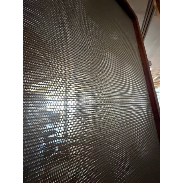 These custom steel mesh room screens combine warm wood framing with translucent industrial mesh panels, creating a...