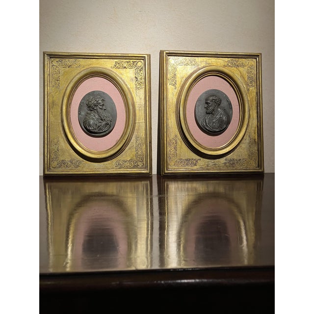 A refined pair of antique gesso medallions—also described as oval portrait plaques or relief portraits—depicting saints...