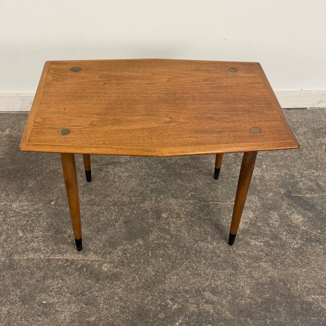 A classic mid-century Scandinavian side table by DUX, featuring a warm teak top with softly contoured edges and elegant...