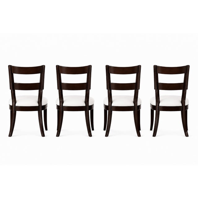 Beautiful set of 4 Klismos dining chairs. Made of alder with custom ebony finish. The seats are upholstered in a cream...