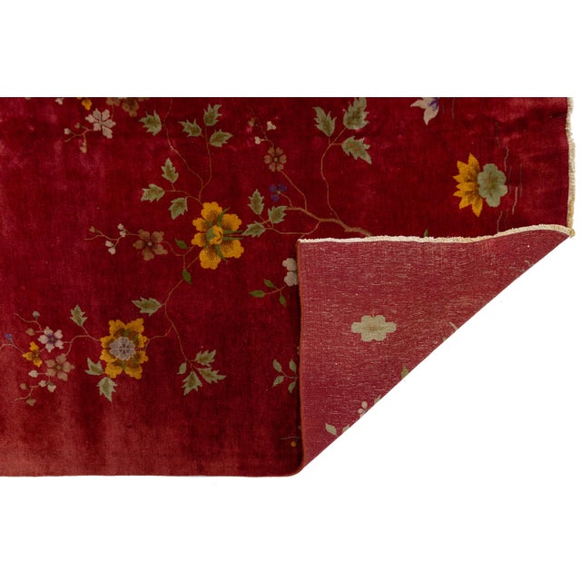 Beautiful antique Chinese Art Deco hand knotted wool rug with a red field. This Chinese rug has multi-color accents in a...