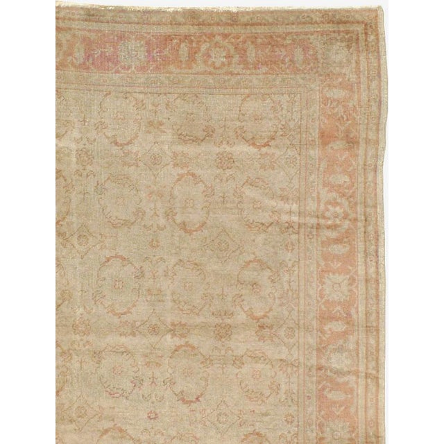 An antique Turkish Oushak large carpet. Small, open brown-outlined ovals are neatly spaced all over the tan field of this...