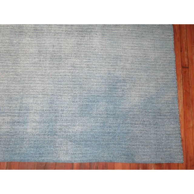 Square size hand-knotted Turkish Kilim in a blotchy aqua blue color. Handwoven by recycled cotton and goat hair material...