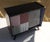Vintage chest of drawers with one sliding door in a PU lacquered finish and one sliding glass door with a gold-tone...