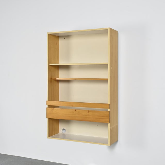 A wall-mounted display cabinet in solid pine, designed by Charlotte Perriand to complement the wall units in the Pierre...