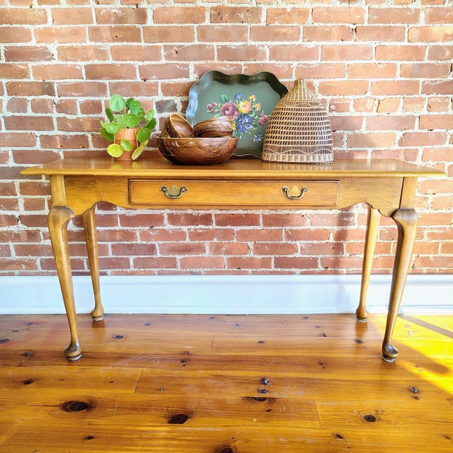 This vintage Ethan Allen side console table features classic American traditional lines with elegant cabriole legs and a...