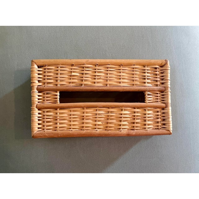 A vintage wicker-work tissue box cover trimmed with round wood pieces at the edges and in the center made for rectangular...