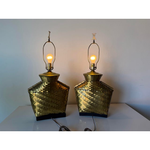 Elegant pair of vintage Chapman table lamps from 1976 featuring an intricate brass basketweave design with strong...