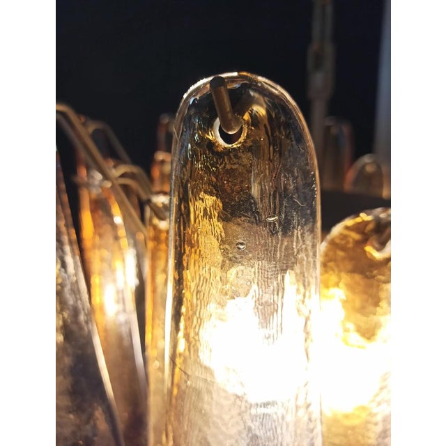 Pair of Chandeliers with 36 transparent with an amber spot inside glasses, gold painted structure. The glasses are very...