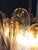 Pair of Chandeliers with 36 transparent with an amber spot inside glasses, gold painted structure. The glasses are very...