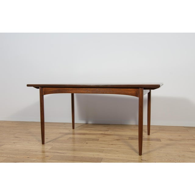 This is a rectangular-shaped teak dining table manufactured by G-Plan in the 1960s. The table has reinforced edges of the...