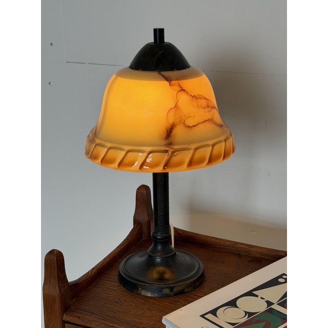 This table lamp dates from the Art Deco period and is Scandinavian in origin. The bell-shaped shade is pressed glass in a...