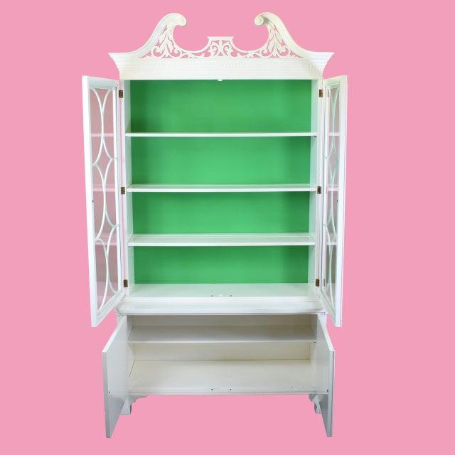A tall mid-century cabinet in white with ornamental detailing, standing over eighty inches for dramatic storage and...