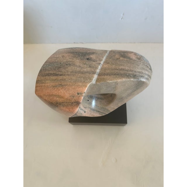 Striking abstract marble sculpture having marvelous pink, grey and white lively grain, on custom black base.
