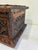 A substantial vintage wooden trunk featuring beautifully executed hand-carved floral motifs on the lid and all visible...