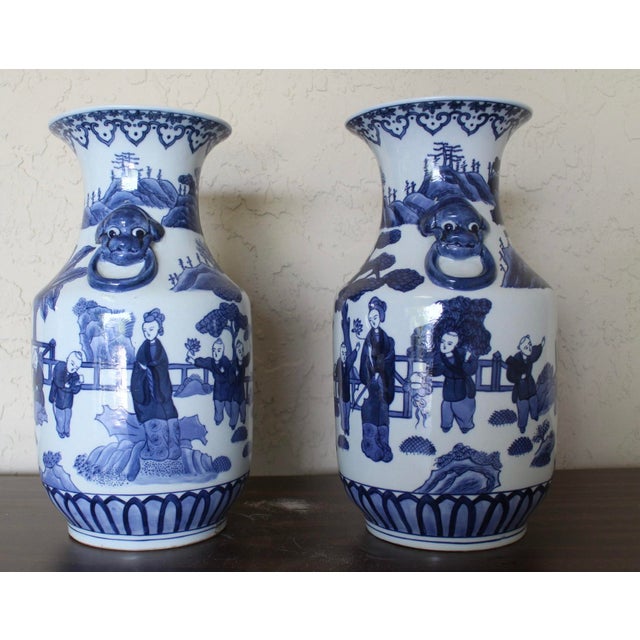 Elegant pair of blue and white Chinese porcelain vases featuring richly detailed figural and landscape scenes with...