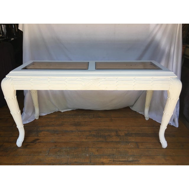 Matte white painted wood console table in the style of Serge Roche. This Hollywood Regency style sofa table features a...
