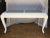 Matte white painted wood console table in the style of Serge Roche. This Hollywood Regency style sofa table features a...