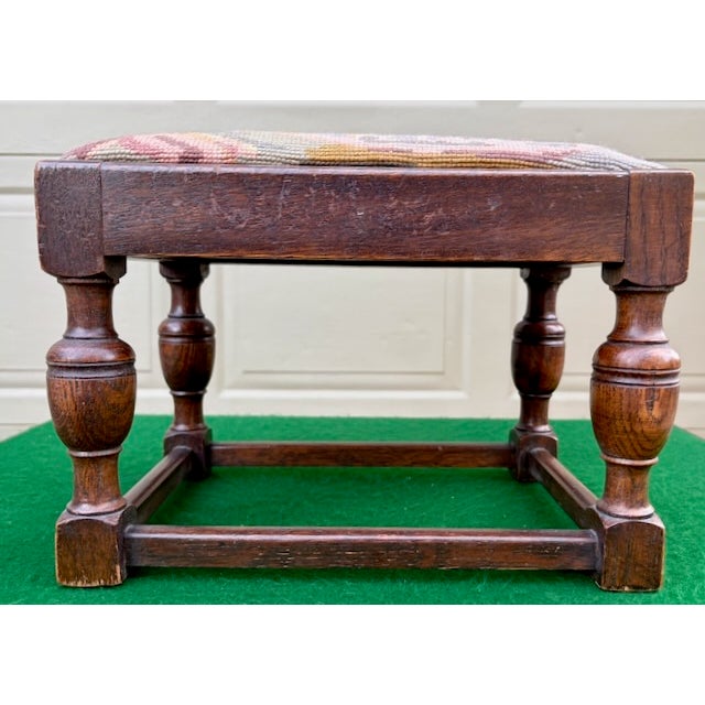 Vintage stool with turned legs and a traditional, hand-stitched needlepoint top depicting a woodland scene with deer.