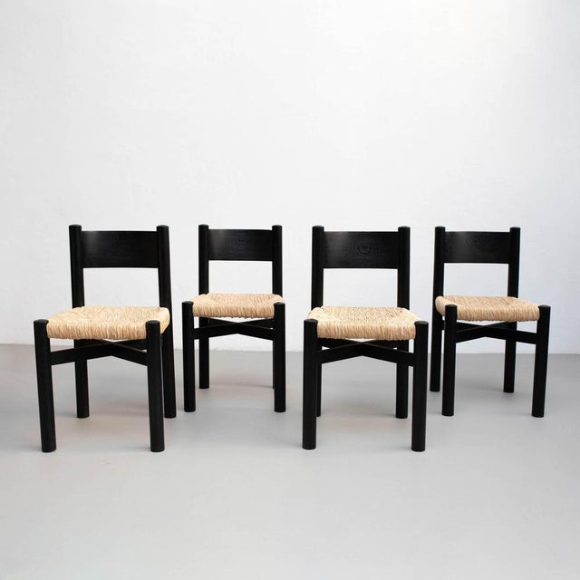 Set of four wood and rattan chairs after Charlotte Perriand, circa 1980. Unknow manufacturer. In good original condition,...