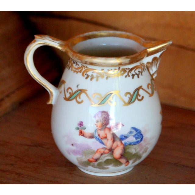 This is an antique hand painted porcelain Royal Vienna creamer from the mid to late 18th century. The creamer measures 3...