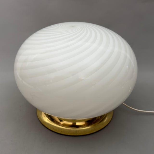 A majestic and dramatic table lamp in artistic glass, attributed to a Murano factory from the 1970s. Subject and Style: An...
