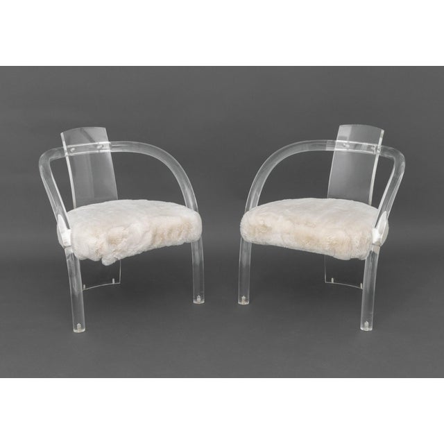 Pair of Charles Hollis Jones Style Lucite Arm Chairs, each seat upholstered in white faux fur. 26.5" H x 23.5" W x 21" D;...