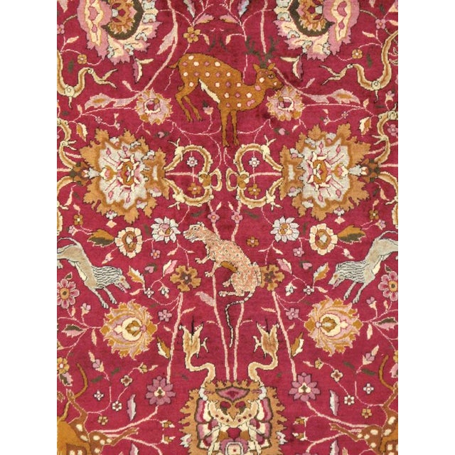 An antique Indian Lahore carpet, from the first quarter of the 20th century, with an allover pictorial design over a red...