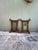 A pair of vintage paintings on wood board depicting tropical palm trees in lush greens and golden light, each framed in...