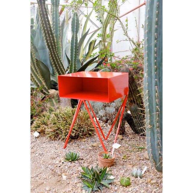 The Robot side table features an open shelf on zig zag legs. A minimal design made in solid steel, powder coated in red....