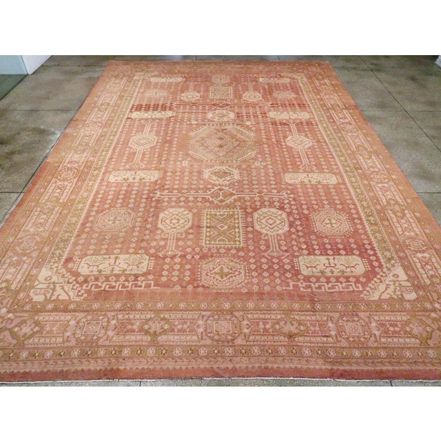 The light brown field of this early 20th century Turkish carpet displays a central octagon with smaller up design...