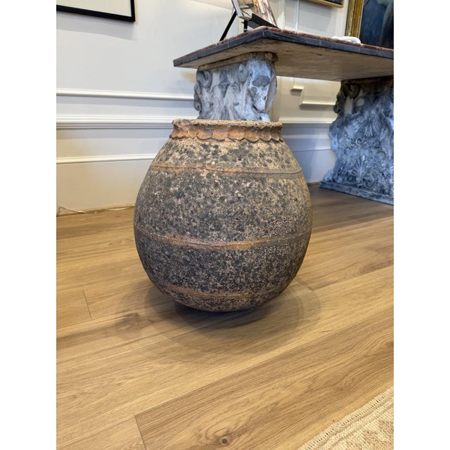 Substantial antique earthenware vessel featuring a beautifully weathered surface with natural mineral deposits, aged...